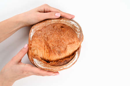 Round homemade bread in hands, on an isolated background. High quality photoの写真素材
