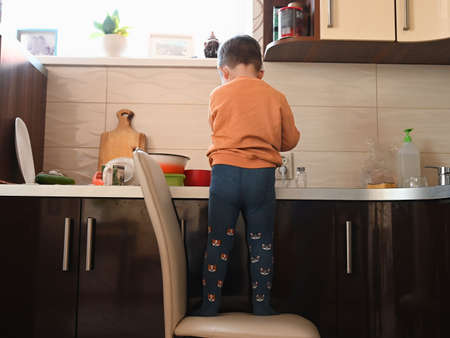 Child in the kitchen preparing food, back view. High quality photoの写真素材