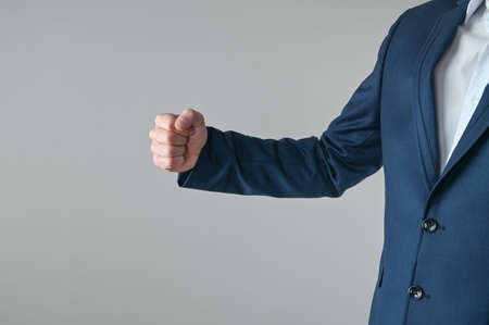 a man in a suit shows his fist. High quality photoの写真素材