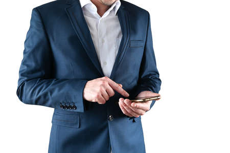 A man in a suit holds a smartphone in his hands, on an isolated background. High quality photoの写真素材