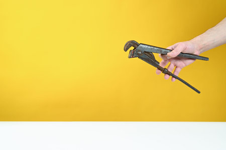 Rusty key in hand on yellow background. High quality photo