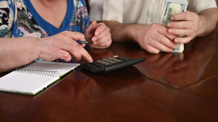 An old married couple are counting the cash savings, close-upの写真素材