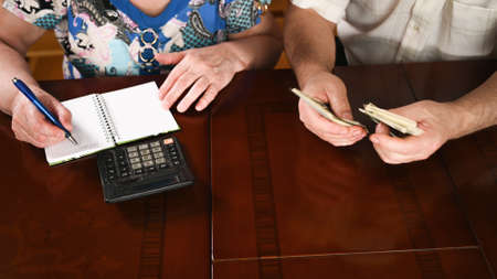 Top view of an old married couple are counting the cash savings, close-upの写真素材