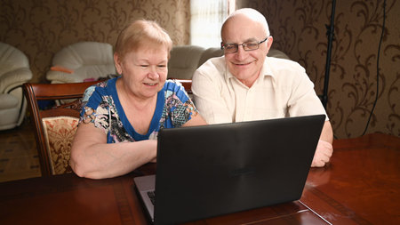 Portrait of happy old senior couple with laptop computer having video call chat. Retirement senior couple old age lifestyle communicating technology connection people conceptの写真素材