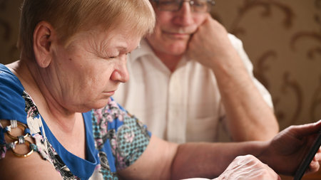 Close up of an elderly couple uses a digital tablet. Communicate connecting technology people....