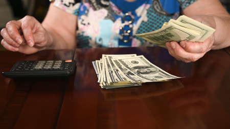 Small pension concept. Woman counts on the dollar.の写真素材