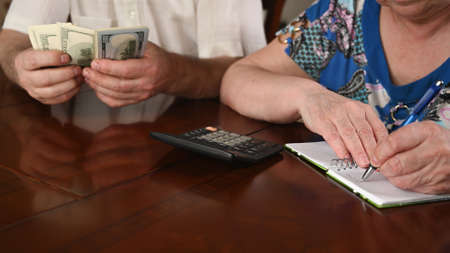 An old married couple are counting the cash savings, close-upの写真素材