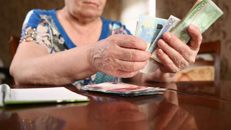 An elderly woman keeps track of her savings.の写真素材