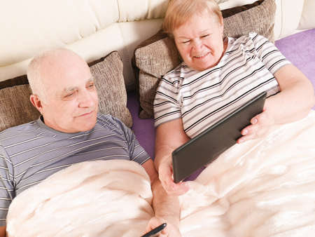 elderly couple with mobile devices.の写真素材