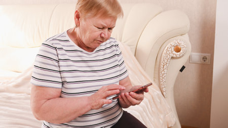 Elderly woman with a phone in her hands, bottom view.の写真素材
