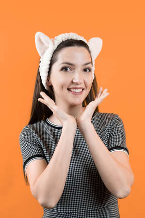 Young girl with ears, on an orange background.の写真素材
