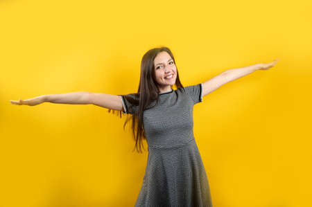 Portrait of a young positive girl, on a yellow background.の写真素材