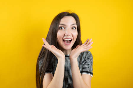Portrait of a young positive girl, on a yellow background.の写真素材