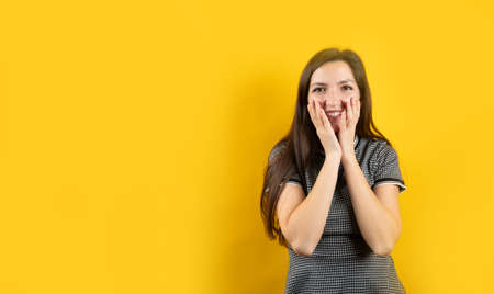 Portrait of a modest young girl, on a yellow backgroundの写真素材