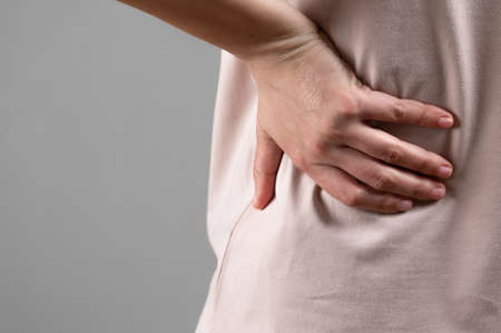 The woman has a pain in the lower back.の写真素材