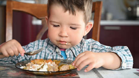 Child in shirt eating close up.の写真素材
