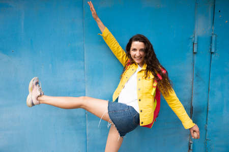 Cheerful young girl on a blue background.の写真素材