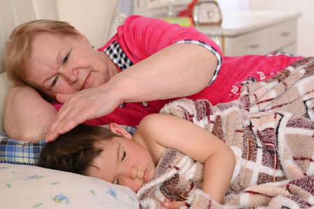 Grandmother puts the child to bedの写真素材