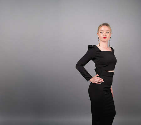 Beautiful blonde in a black dress on an isolated background.の写真素材