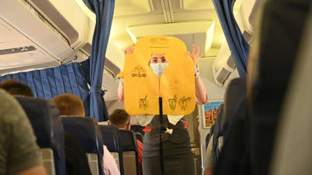 Minsk, Belarus - June 5, 2021: The stewardess shows the safety rules on the plane.のeditorial素材