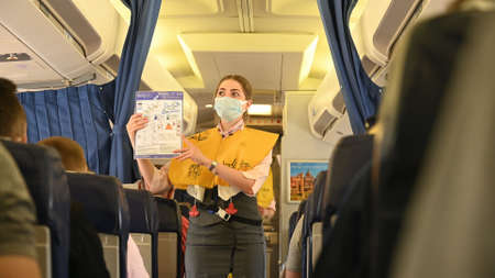Minsk, Belarus - June 5, 2021: The stewardess shows the safety rules on the plane.のeditorial素材