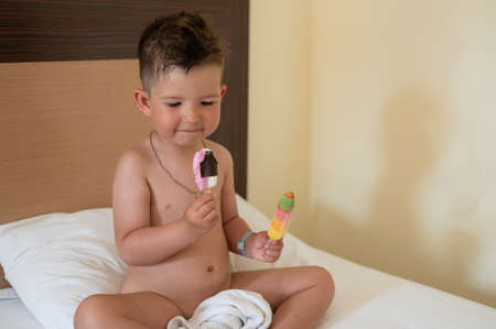 The child eats two ice creamsの写真素材