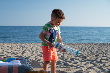 Child on the beach with a water gunの写真素材