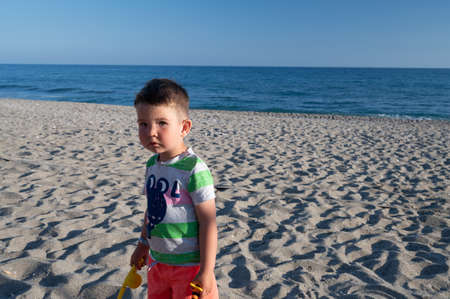 Little boy looking for his mom on the beachの写真素材
