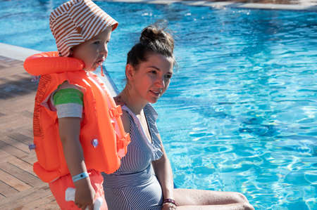 Child in a life jacket near the poolの写真素材