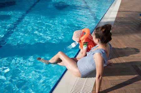 Child in a life jacket near the poolの写真素材