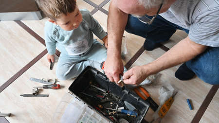 Grandfather shows his grandson his toolbox. Learning and development conceptの写真素材