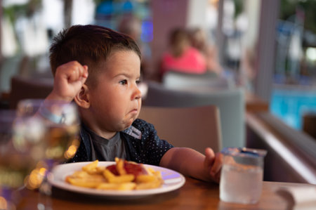 The child is sitting alone in a restaurant.の写真素材