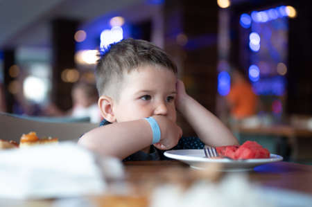 The child is sitting alone in a restaurant.の写真素材