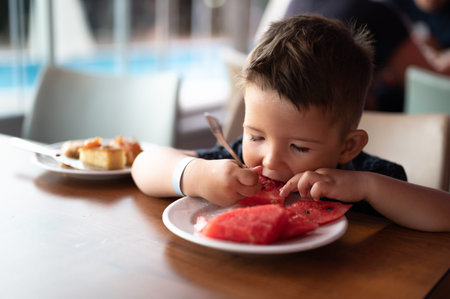 The child loves to eat watermelon.の写真素材