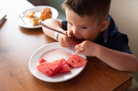 The child loves to eat watermelon.の写真素材