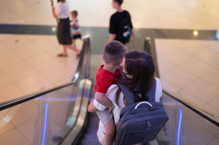 Mom with a child in her arms, descend on an escalator.の写真素材