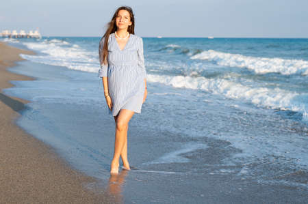 Young woman walking near the sea.の写真素材