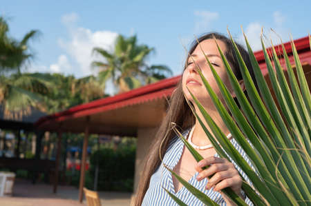 Young woman near foliage under the sun.の写真素材