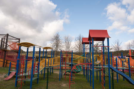 Empty childrens swing in the park, wooden benches, slides, sports equipment.の写真素材