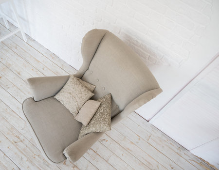 Top view of biege cozy armchair with pillow in room. Minimalist interior conceptの写真素材