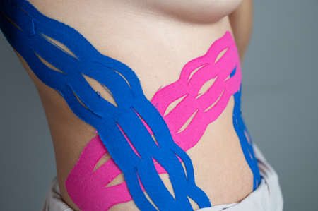 Anti-cellulite procedure for slim belly. Close up of kinesiology tape on female tummy. Diastasis correction conceptの写真素材