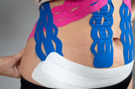 Anti-cellulite procedure for slim belly. Close up of kinesiology tape on female tummy. Diastasis correction conceptの写真素材