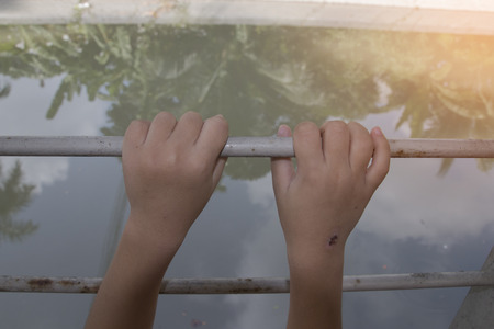 two hands of a man are grabbing steel cageの写真素材