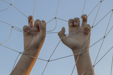 Hand holding football goal net.の写真素材