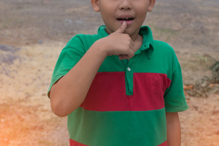 The boy's mouth hand gestureの写真素材