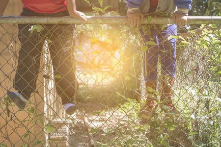 Child climbs over a wire fenceの写真素材