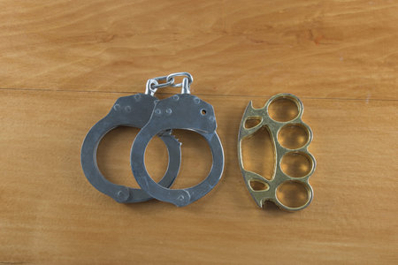 Handcuffs and knuckles on the wooden floor