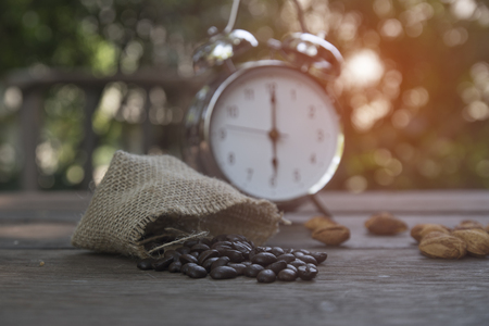 coffee beans on wooden table alarm clock background.の写真素材
