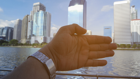 Close-up of  hand on background of modern buildingの写真素材