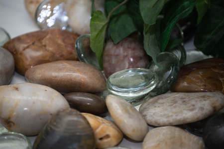 Still life photo of decorative rocks, stones and glass, with plants blurred